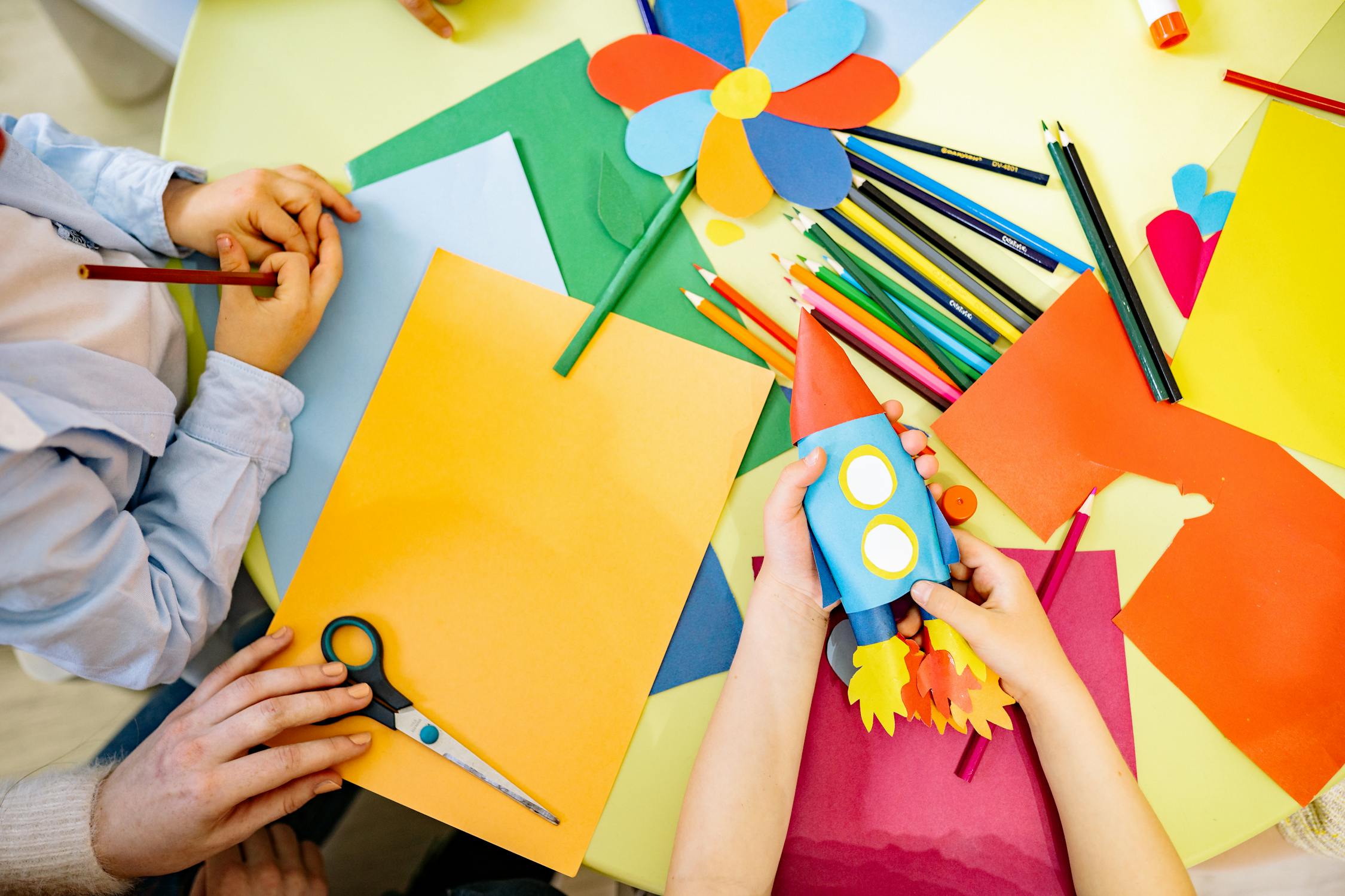 Kinder beim Basteln mit buntem Papier