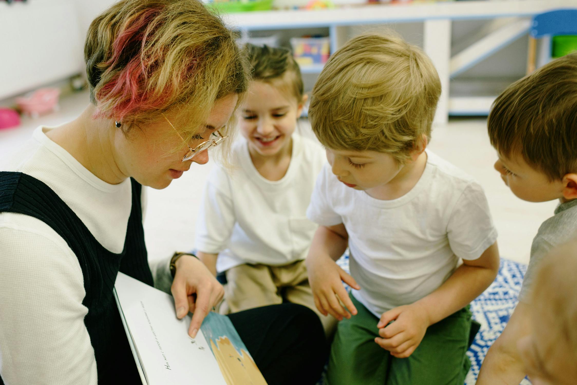 Erzieherin zeigt Kindern ein Bilderbuch